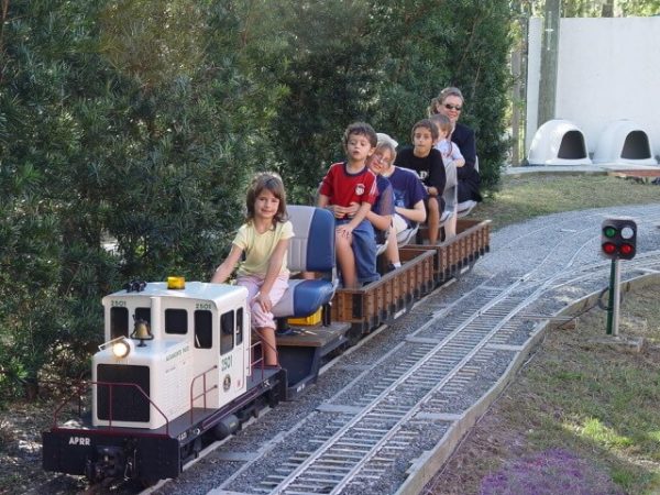 Riders on wood-sided rider cars behind a 65-ton RMI locomotive