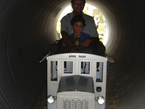 Riders on a miniature train inside a tunnel at Altamonte Pass Railroad