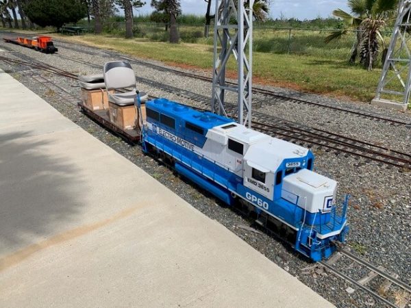 Blue and white diesel locomotive pulling flat cars