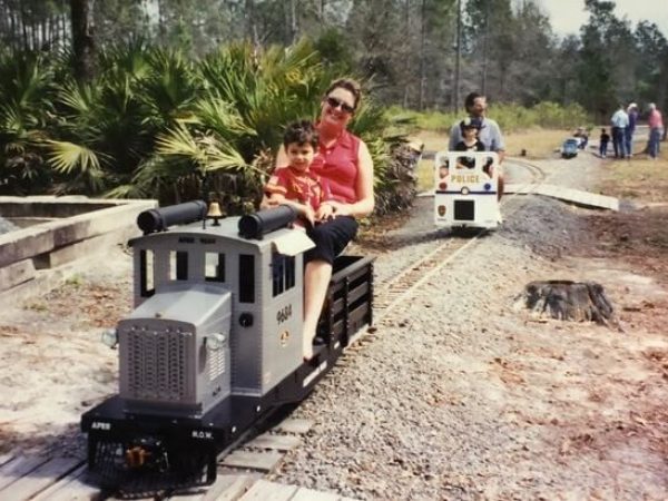 Mother and child riding a gray diesel locomotive