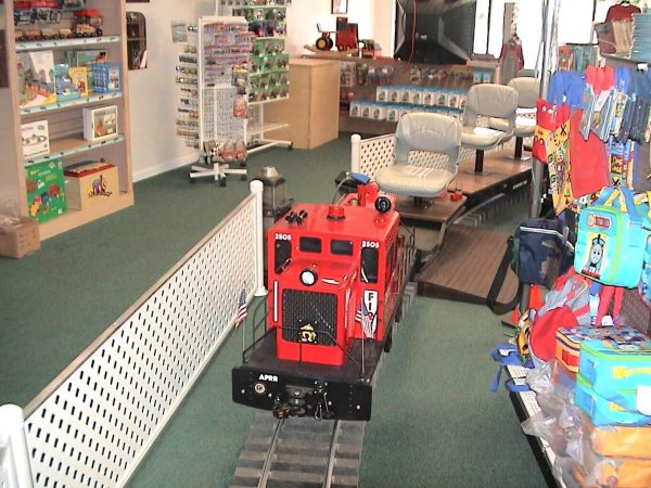 Red miniature locomotive on display indoors